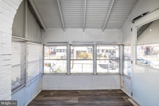 unfurnished sunroom featuring lofted ceiling with beams