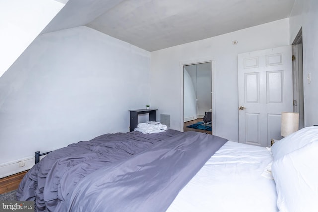 bedroom with dark hardwood / wood-style floors and a closet