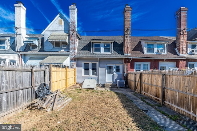 rear view of property with central AC