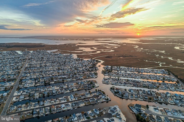 aerial view at dusk featuring a water view