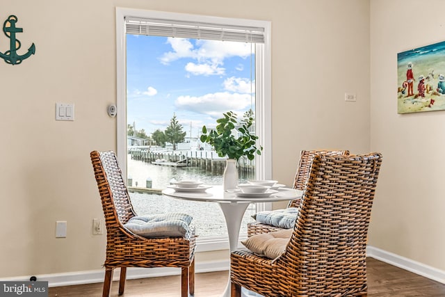 dining area with a water view and hardwood / wood-style flooring