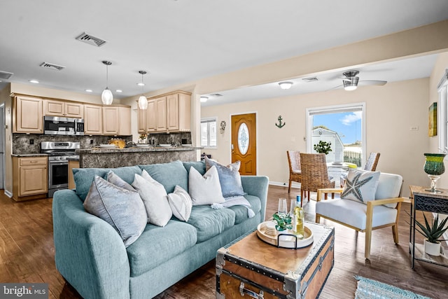 living room with ceiling fan, dark wood-type flooring, and a wealth of natural light