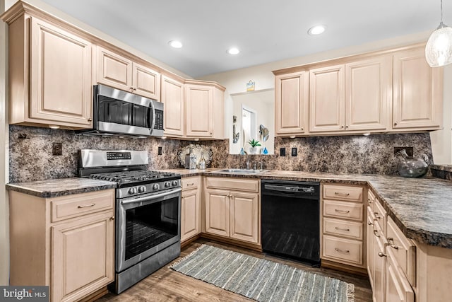 kitchen featuring sink, dark hardwood / wood-style flooring, hanging light fixtures, stainless steel appliances, and decorative backsplash