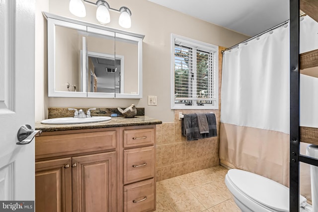 bathroom featuring toilet, curtained shower, vanity, and tile patterned flooring