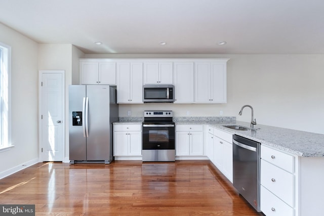 kitchen featuring sink, white cabinets, stainless steel appliances, and hardwood / wood-style flooring