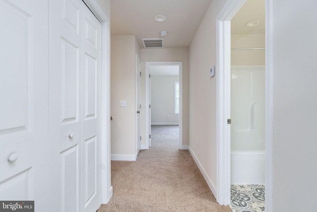 corridor featuring light colored carpet