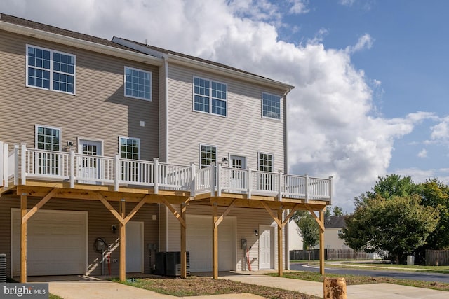 back of property with a deck and a garage