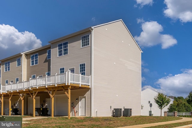 back of house featuring central air condition unit and a wooden deck