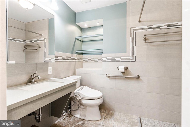 bathroom featuring toilet, tile walls, sink, and tiled shower