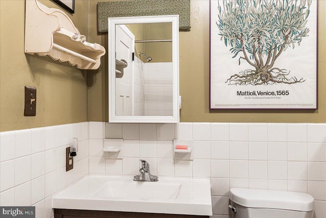 bathroom featuring a tile shower, vanity, and toilet