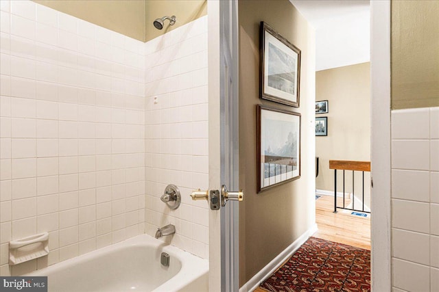 bathroom with tiled shower / bath combo and wood-type flooring