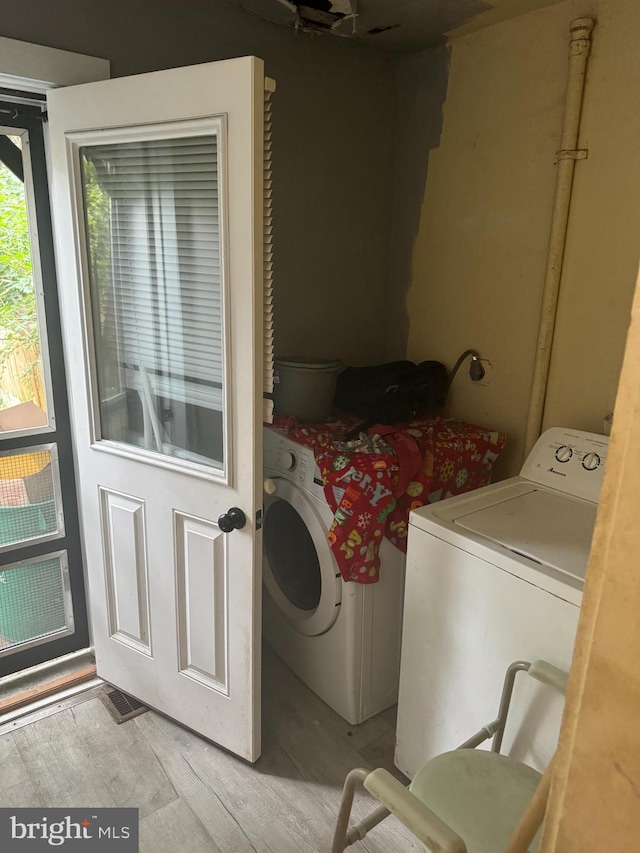 washroom with washer and clothes dryer and light wood-type flooring