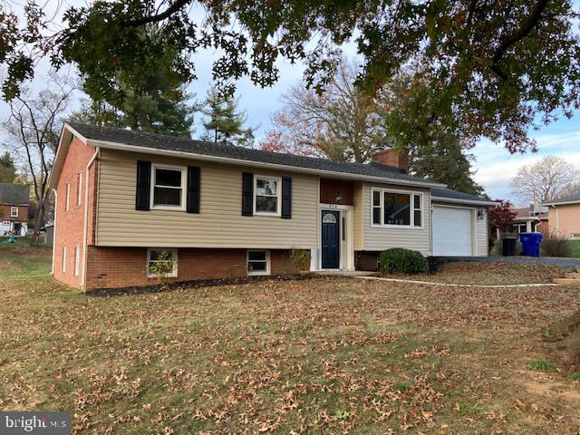 bi-level home with a front yard and a garage