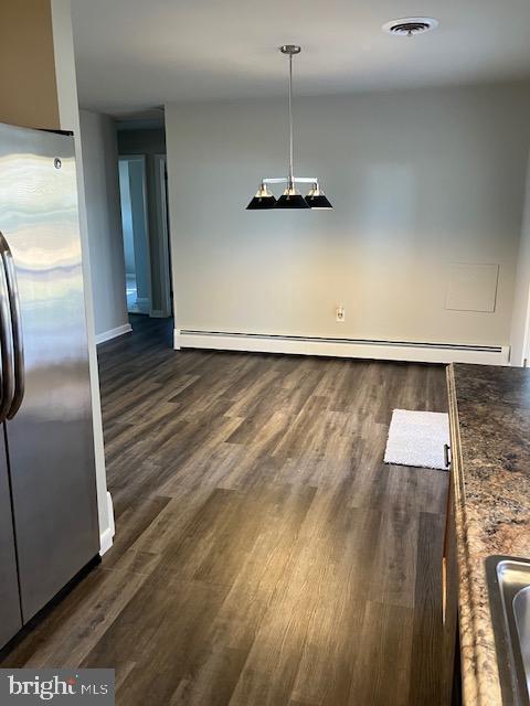 unfurnished dining area featuring a baseboard radiator and dark hardwood / wood-style floors