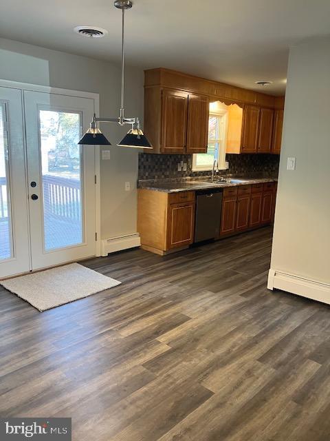 kitchen with stainless steel dishwasher, hanging light fixtures, dark hardwood / wood-style floors, and plenty of natural light