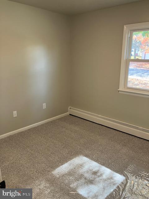 empty room featuring carpet and baseboard heating