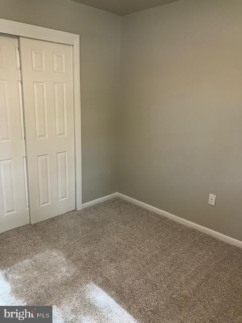 unfurnished bedroom featuring a closet and carpet flooring