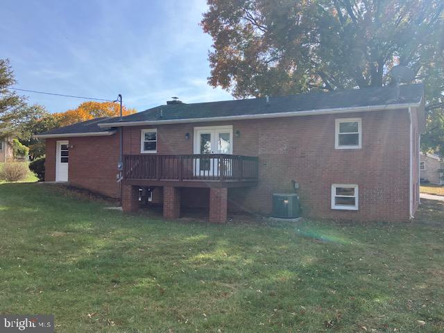 rear view of house featuring a wooden deck, a yard, and central air condition unit