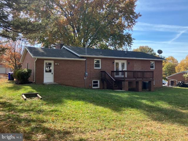 rear view of house featuring a deck and a lawn