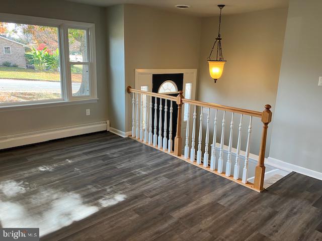 interior space featuring baseboard heating and wood-type flooring