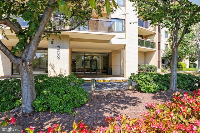 view of exterior entry with a balcony