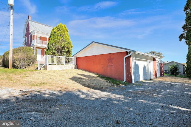 view of property exterior with an outdoor structure, concrete block siding, and a detached garage