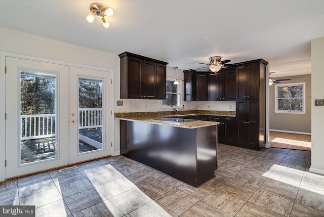 kitchen featuring french doors, kitchen peninsula, ceiling fan, decorative light fixtures, and dark brown cabinets