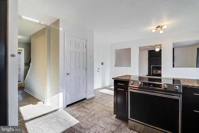 kitchen featuring electric range, ceiling fan, and stone counters