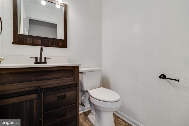 bathroom featuring vanity, hardwood / wood-style flooring, and toilet