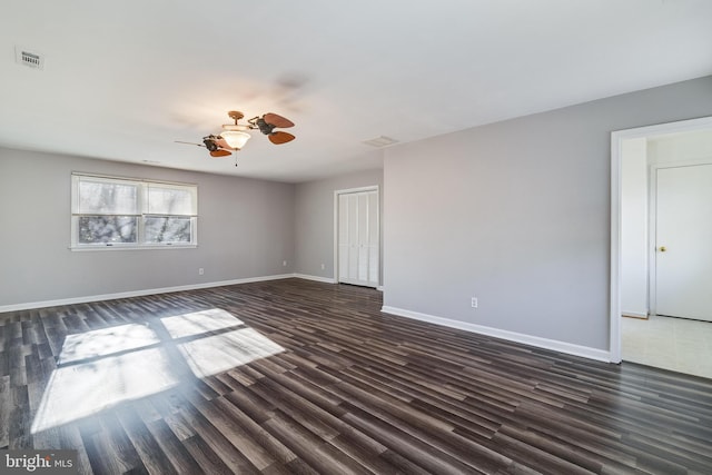 spare room with dark hardwood / wood-style floors and ceiling fan