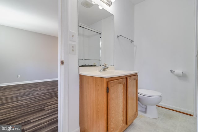 bathroom with a shower with door, vanity, hardwood / wood-style floors, and toilet