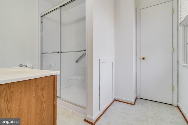 bathroom with vanity and a shower with door