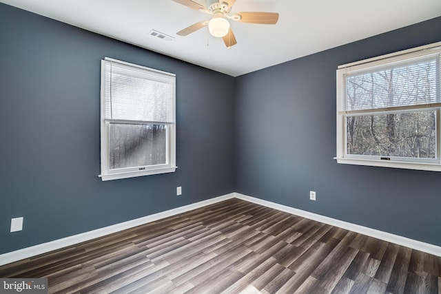 unfurnished room featuring dark hardwood / wood-style floors, ceiling fan, and a healthy amount of sunlight