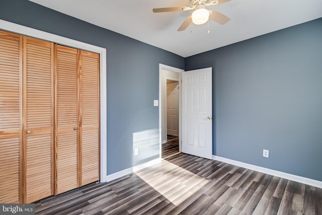 unfurnished bedroom with ceiling fan, a closet, and dark wood-type flooring