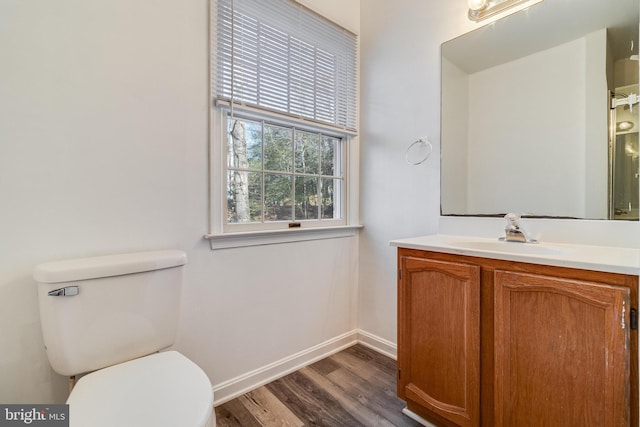 bathroom with wood-type flooring, vanity, and toilet