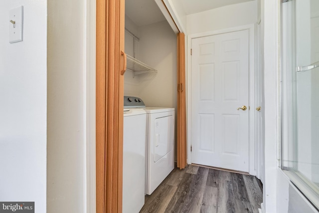 laundry room with washer and dryer and dark wood-type flooring