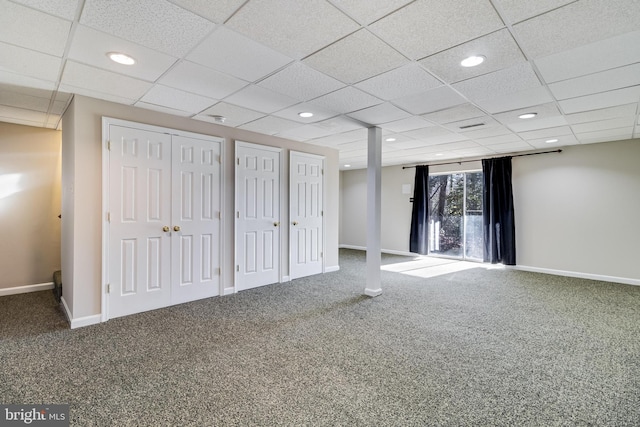 basement featuring a paneled ceiling and carpet floors