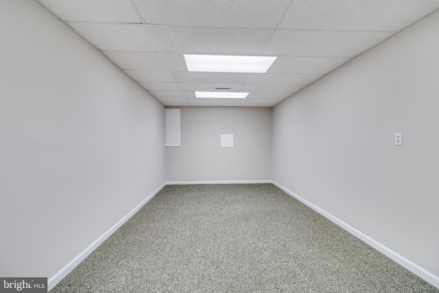 carpeted spare room featuring a drop ceiling