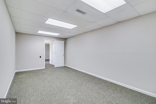 carpeted empty room with a paneled ceiling