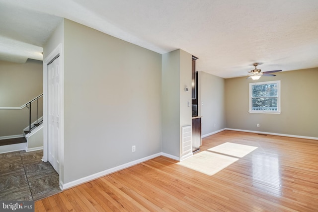 empty room featuring hardwood / wood-style floors, a textured ceiling, and ceiling fan