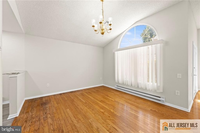 unfurnished room featuring a baseboard radiator, hardwood / wood-style floors, a textured ceiling, and an inviting chandelier