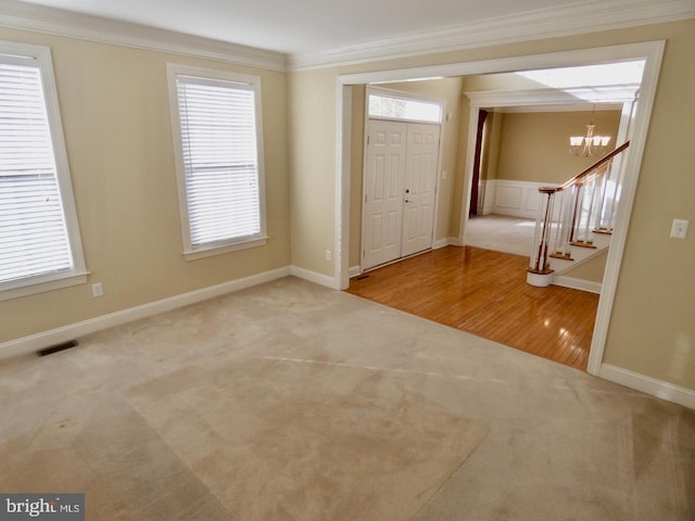 entryway with wood-type flooring, plenty of natural light, a notable chandelier, and ornamental molding