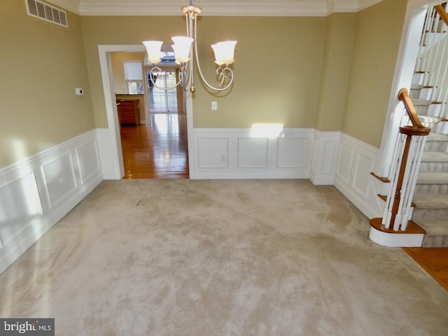 unfurnished dining area with light colored carpet, a chandelier, and ornamental molding