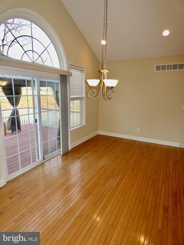 interior space with high vaulted ceiling, light hardwood / wood-style floors, and an inviting chandelier