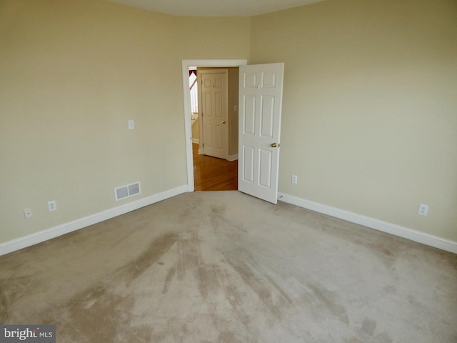 spare room featuring light carpet