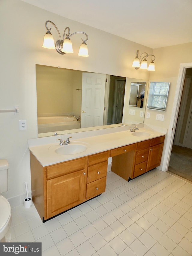 bathroom with tile patterned flooring, vanity, a tub to relax in, and toilet