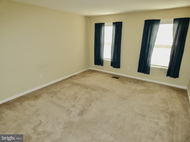 empty room with light carpet and a healthy amount of sunlight