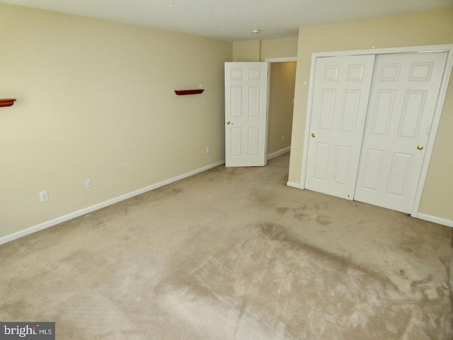 unfurnished bedroom featuring light carpet and a closet