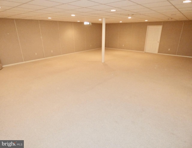 basement featuring a paneled ceiling and carpet floors