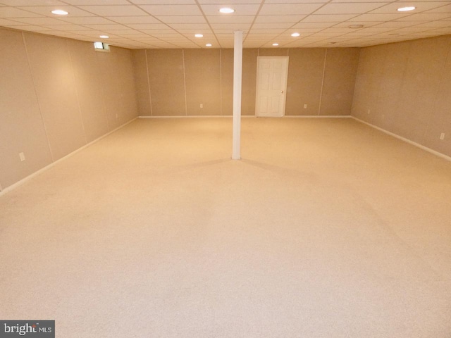 basement with a paneled ceiling and carpet floors